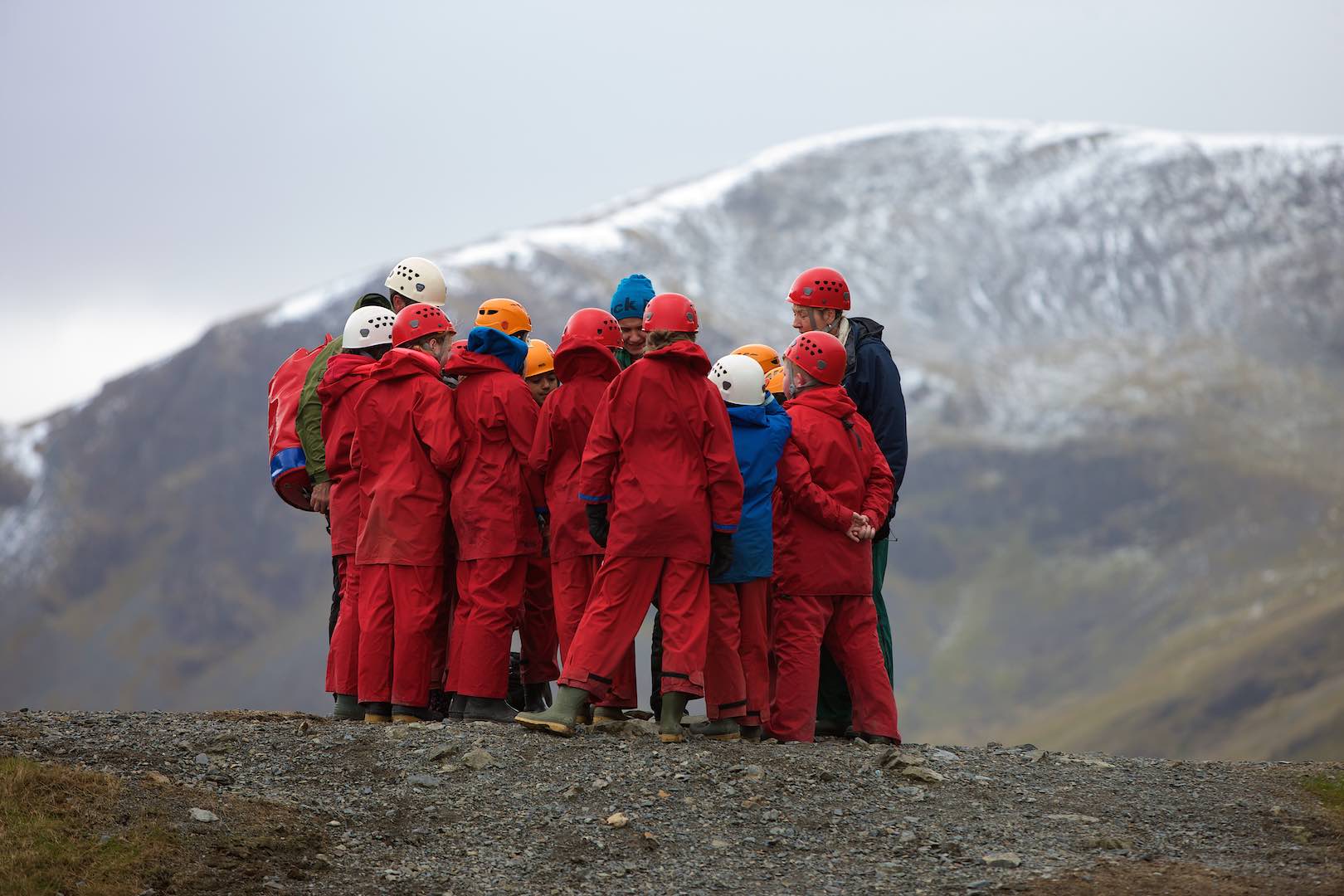 Primary pupils huddled together among the mountains learning about geology 