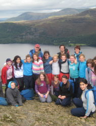 Year six class grouped together on the Summit of Catbells