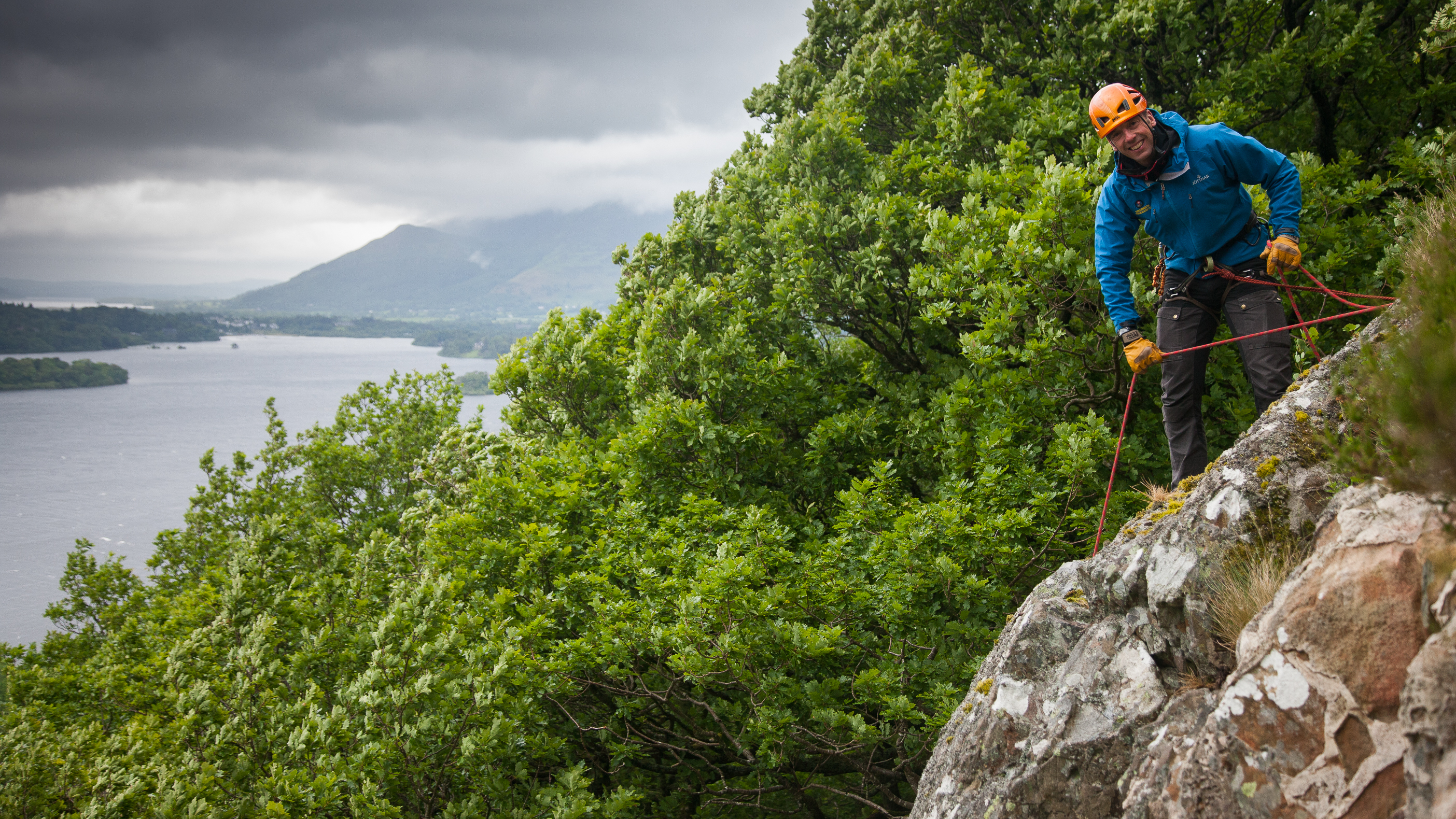 Neale managing an abseil session on a steep cliff above Derwent Water